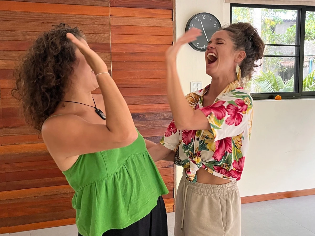 Rosi and another participant laughing together during a movement practice